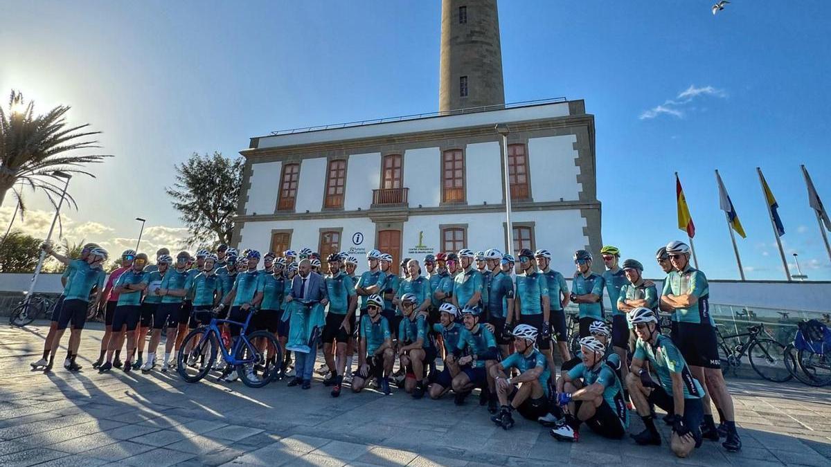 Un grupo de 75 corredores italianos posa a los pies del Faro de Maspalomas junto al consejero de Turismo del Cabildo, Carlos Álamo (centro).