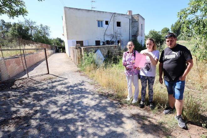 Los desahuciados posan delante de la casa.