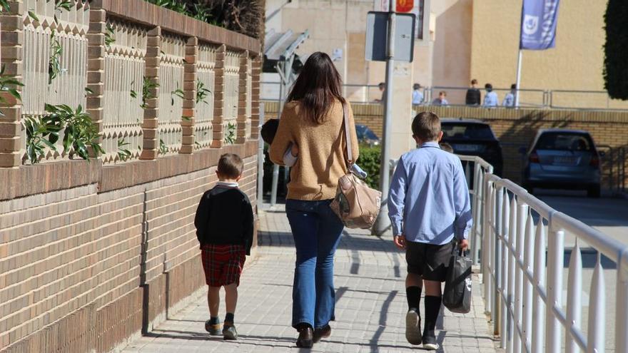 Una madre y alumnos en las inmediaciones de un colegio.