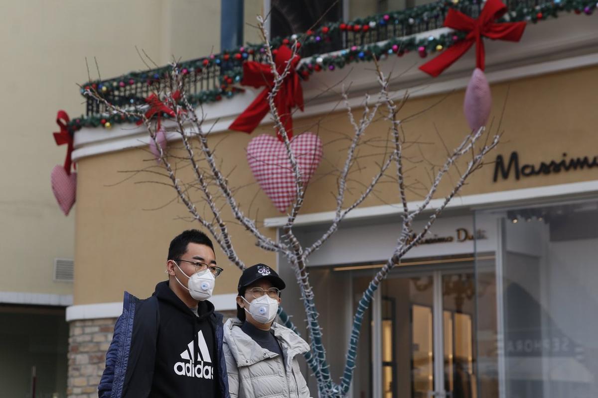 Beijing (China), 12/02/2020.- People wearing protective masks walk in a shopping mall decorated for Valentine’s Day in Beijing, China, 12 February 2020 (issued 14 February 2020). Many flower markets, restaurants, cinemas and others stores closed due to the Covid-19 virus outbreak in China which originated in the Chinese city of Wuhan, has so far killed at least 1,360 people and infected nearly 60,000 others worldwide, mostly in China. (Cine) EFE/EPA/WU HONG