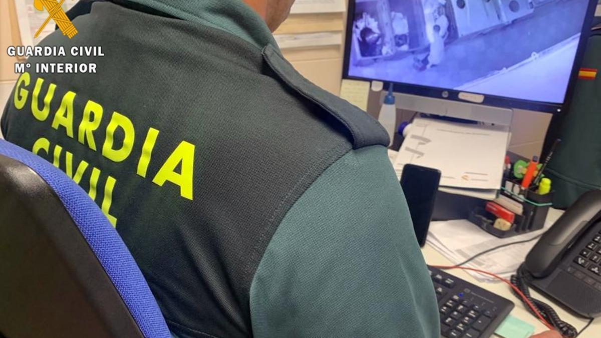 Un guardia civil inspecciona las imágenes de cámaras de seguridad próximas a los contenderos incendiados en Oliva de la Frontera