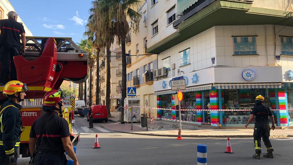 Intervención de los bomberos tras desprenderse parte de una cornisa en la calle Mármoles.