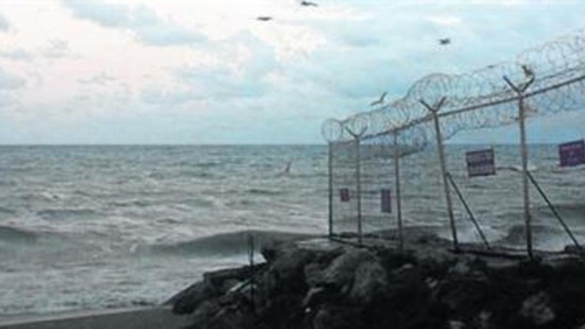 El escenario 8Imágenes del reportaje en las que se ve la playa del Tarajal y la llegada de inmigrantes frente a los policías españoles.