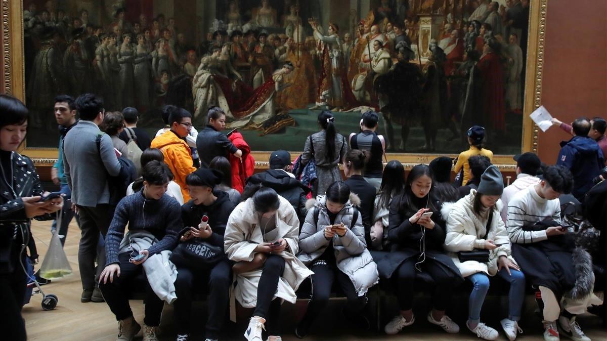 Visitantes en el Museo del Louvre, ante la Coronación de Napoleón.