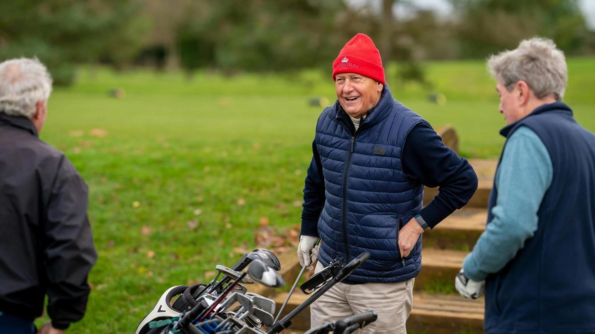 Unas personas mayores disfrutando de un partido de golf.