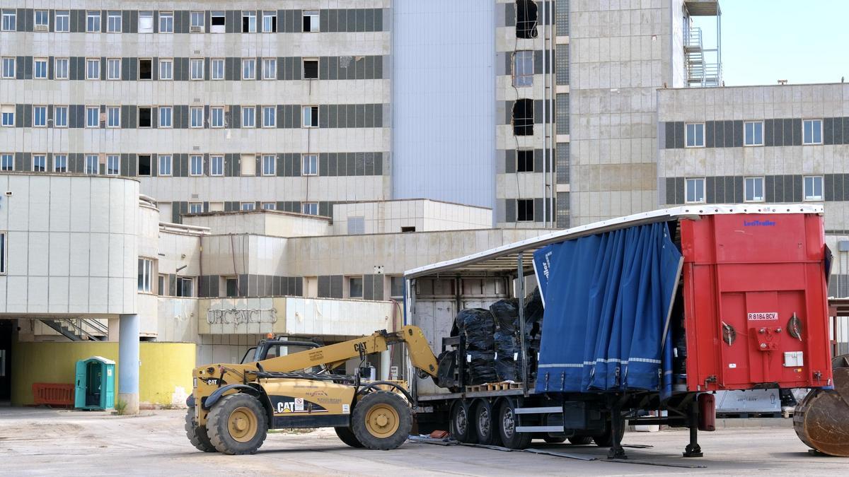 Un operario introduce en un camión contenedor residuos de la demolición de Son Dureta empaquetados con material plástico y etiquetados