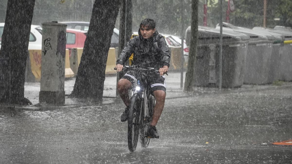 Una bicicleta circula bajo la lluvia en el barrio de Sant Martí