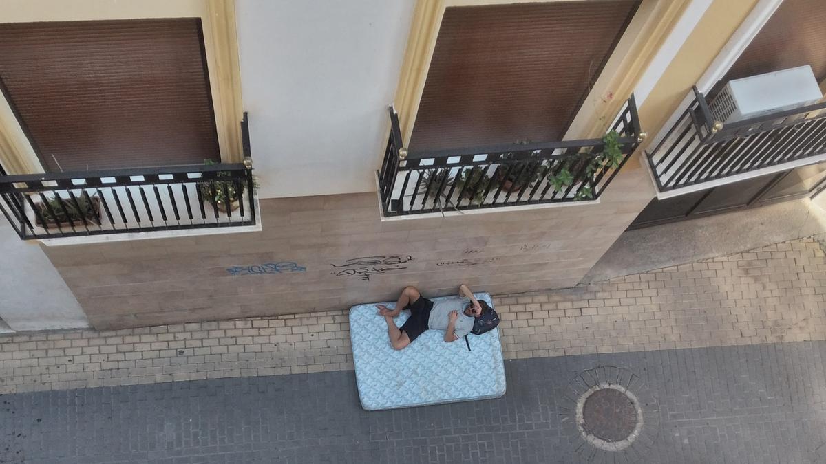 El hombre, durmiendo en un colchón de matrimonio, en medio de una calle del casco antiguo de Lorca, este jueves.