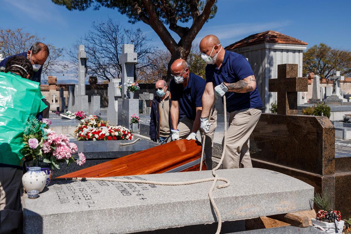 Empleados funerarios entierran a un fallecido por covid en el cementerio de Fuencarral (Madrid), el 29 de marzo de 2020.