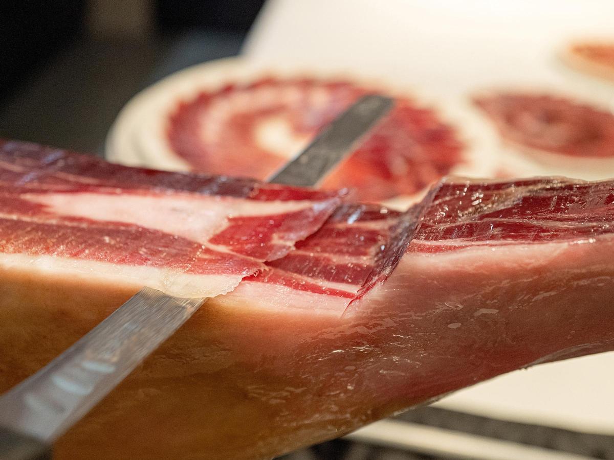 Primer plano de un corte de jamón de bellota 100% ibérico, premiado por Alimentos de España.