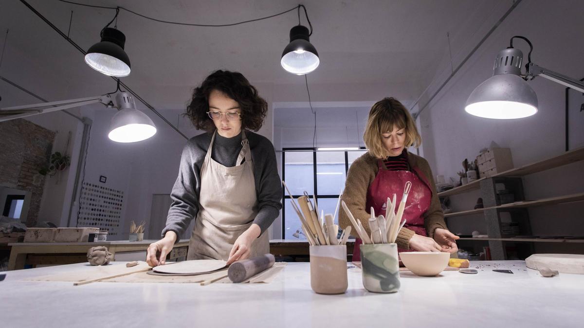 Dos profesionales trabajan en un taller de cerámica.