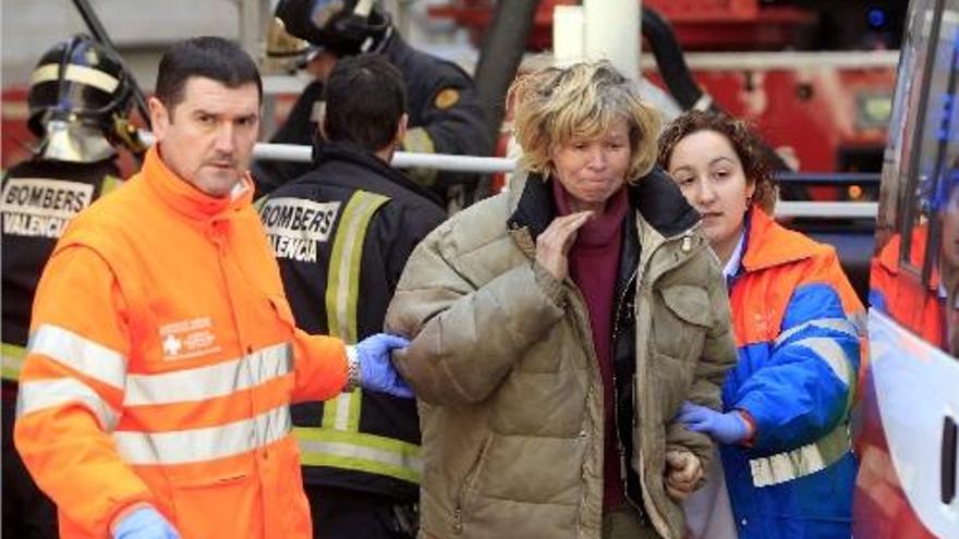 Personal del SAMU acompaña a la ambulancia a la mujer, tras ser rescatada por los bomberos.