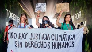 Tres jóvenes activistas se manifiestan durante la cumbre del clima de Sharm el-Sheikh.