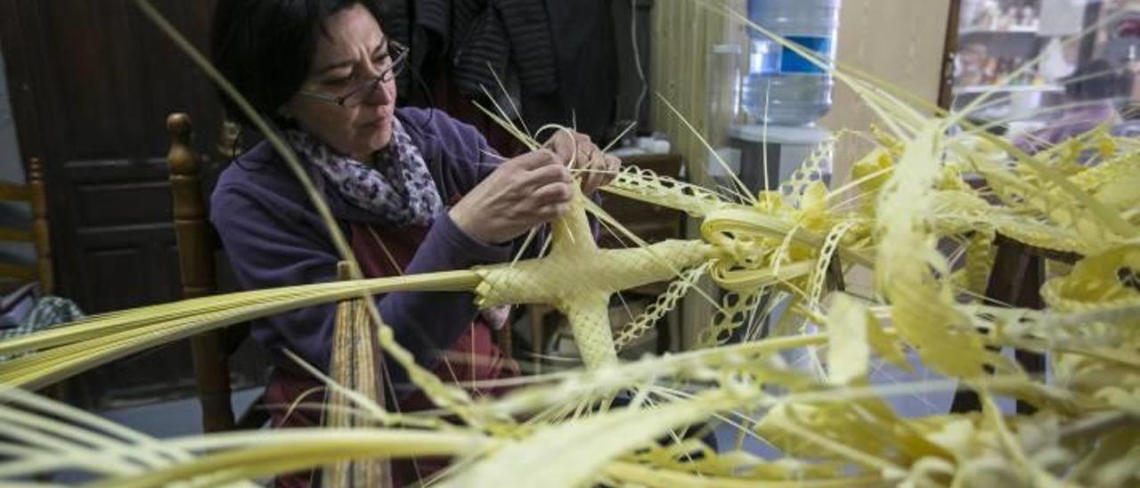 Una artesana de Elche confeccionando una de las palmas blancas rizadas que saldrán a la calle el próximo Domingo de Ramos.