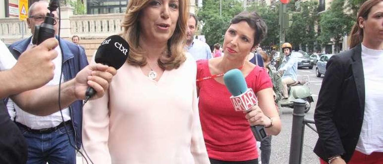 Susana Díaz, ayer por la tarde, rodeada de micrófonos a las puertas de la sede del partido, donde siguió el recuento. // Modem Press