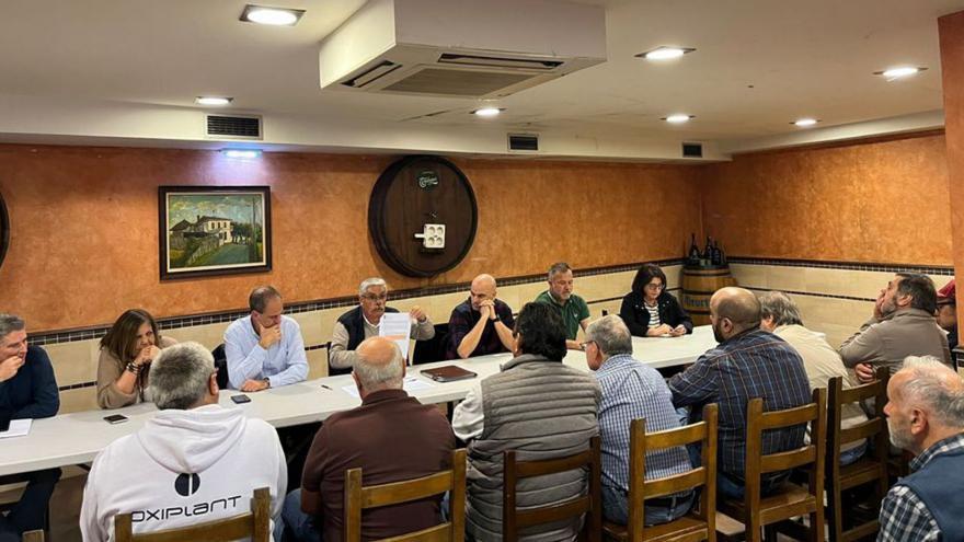 La reunión de la ejecutiva socialista con representantes vecinales, con el portavoz municipal, Luis Manuel Flórez, «Floro», sosteniendo un papel y Monchu García a su izquierda.