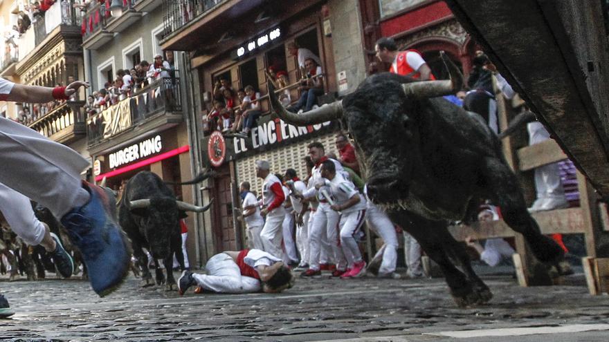 Los mozos corren ante los toros de José Escolar durante el tercer encierro de San Fermín