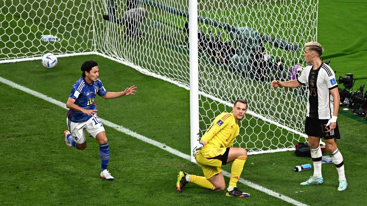 Japan's midfielder #10 Takumi Minamino (L) runs to celebrate as Germany's goalkeeper #01 Manuel Neuer (C) and Germany's defender #23 Nico Schlotterbeck (R) react after conceding a second goal during the Qatar 2022 World Cup Group E football match between Germany and Japan at the Khalifa International Stadium in Doha on November 23, 2022.