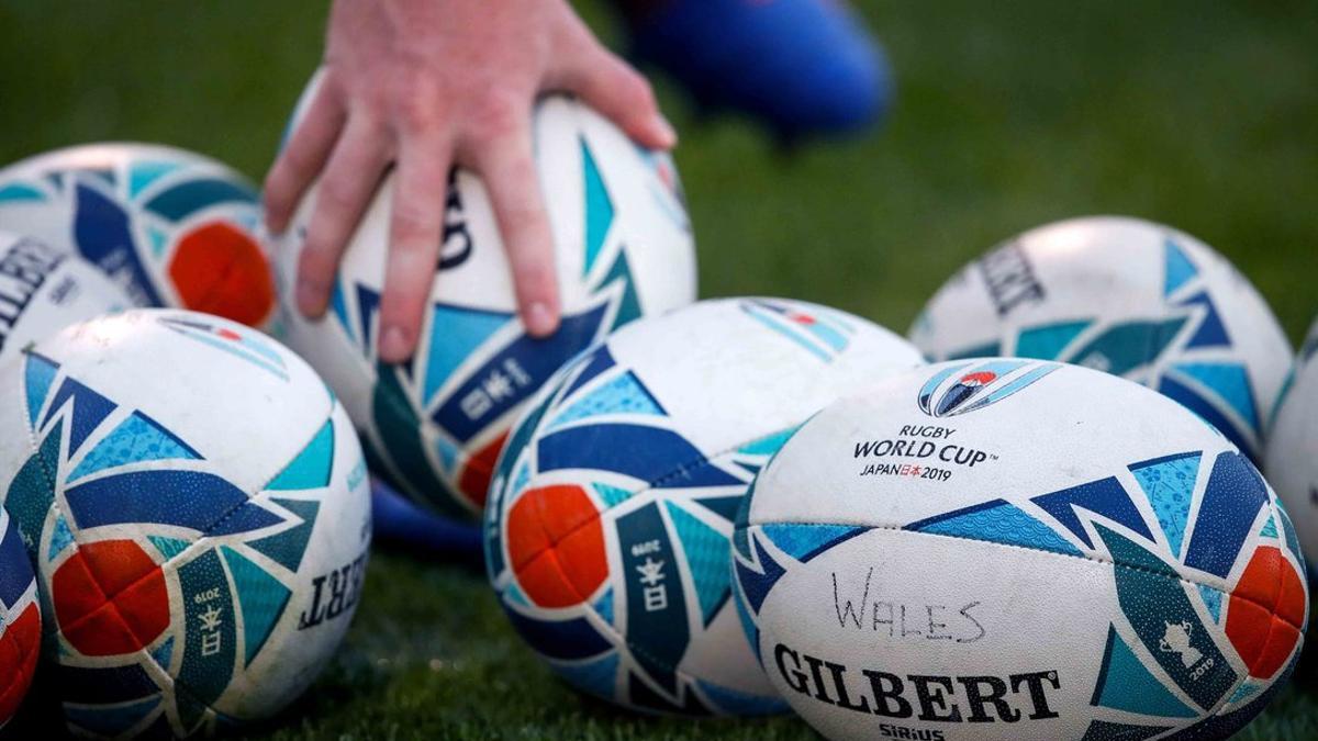 Un jugador recoge una pelota oficial del torneo durante una sesión de entrenamiento del equipo de Gales en Tokio, durante la Copa Mundial de Rugby de Japón 2019.