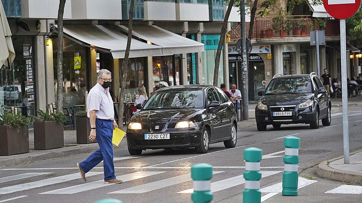 Llorenç Gené creuant un pas de vianants davant d’un dels punts on s’ha tallat el trànsit amb pilones. | MARC MARTÍ