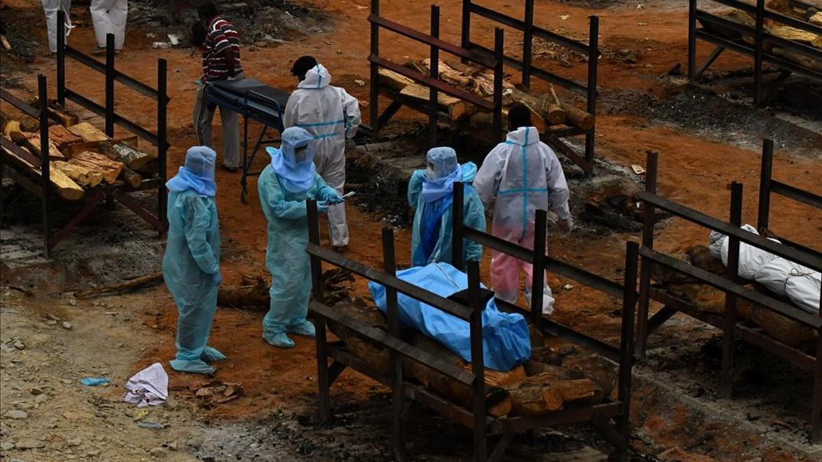 Volunteers and relatives prepare to cremate the bodies of persons who died due to the coronavirus disease (COVID-19)  at a crematorium ground in Giddenahalli village on the outskirts of Bengaluru  India  May 2  2021  REUTERS Samuel Rajkumar