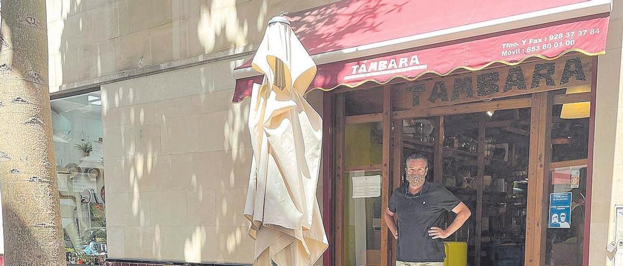 Alberto Pérez en su negocio con la terraza frente a la entrada de la floristería.