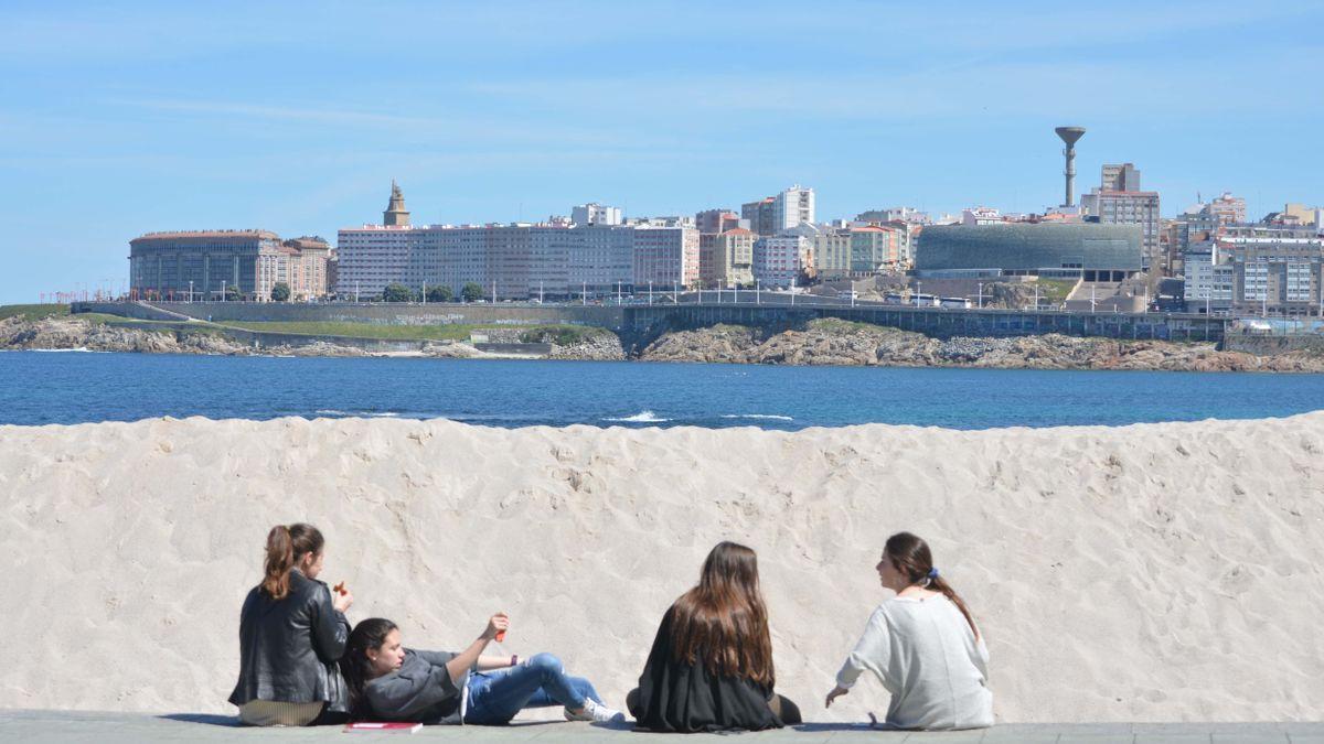 Jóvenes en el paseo marítimo de A Coruña un día soleado de invierno.