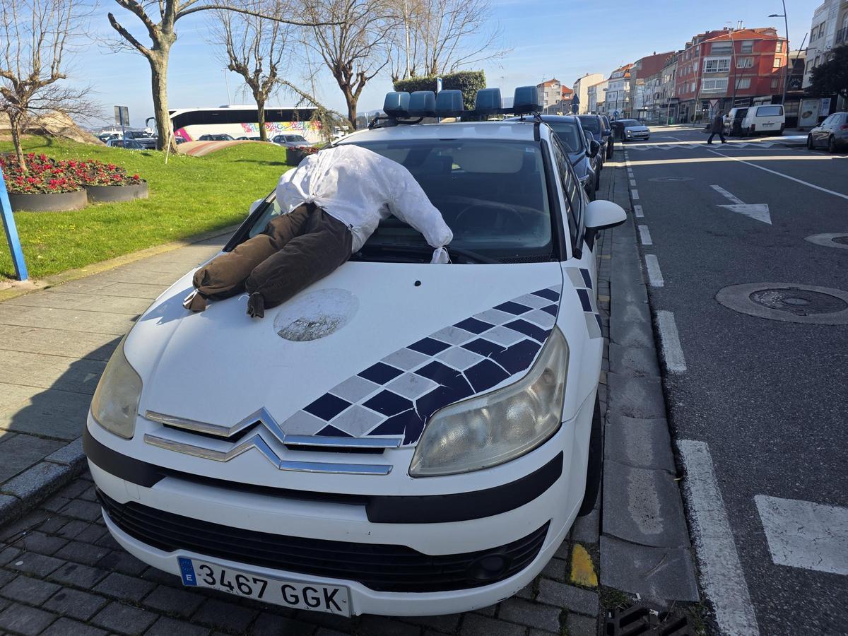 Un coche de la Policía Local con un monigote sobre el capó, el domingo.