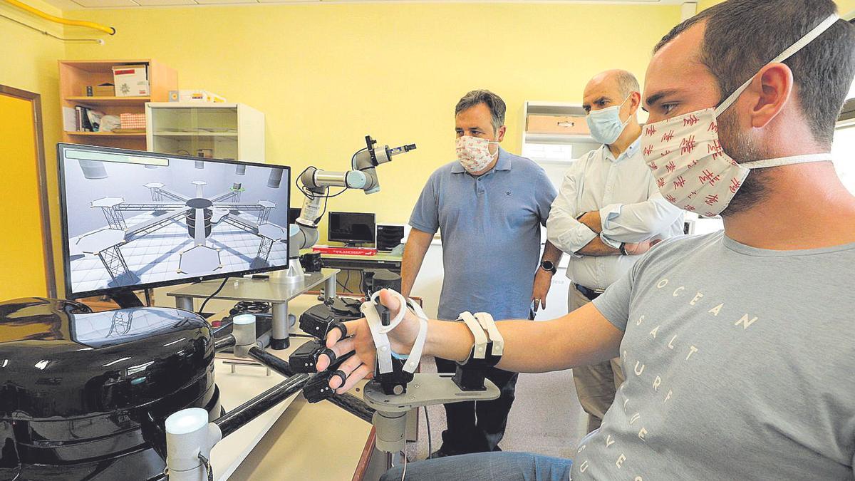 Un joven prueba el robot de rehabilitación para uso doméstico desarrollado por investigadores de la Universidad Miguel Hernández.