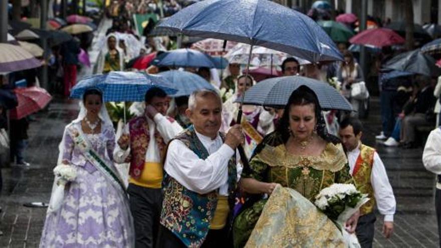 Los festeros realizaron el recorrido completo, algunos protegidos por paraguas, hasta la plaza de España para depositar las flores y los alimentos.