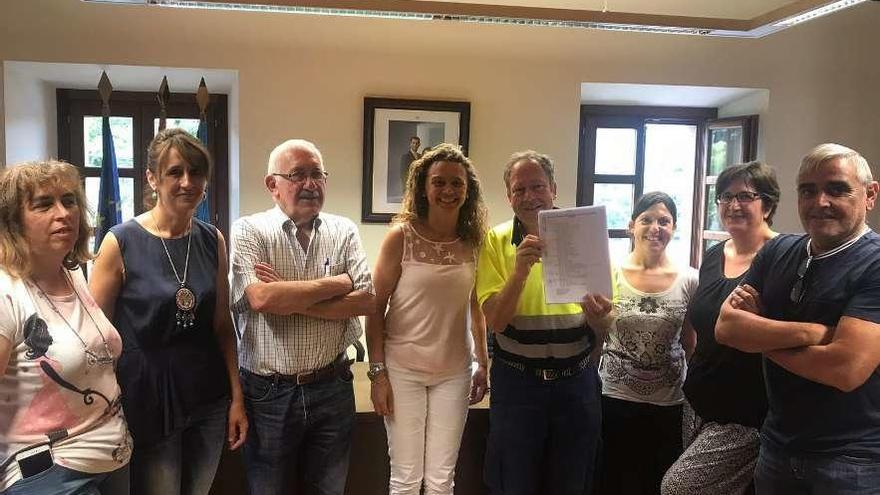 Los ediles María Elena Fernández, Marta Menéndez y Gustavo Blanco, la alcaldesa, Natalia González, y un grupo de trabajadores tras la firma del acuerdo, en el Ayuntamiento de Candamo.