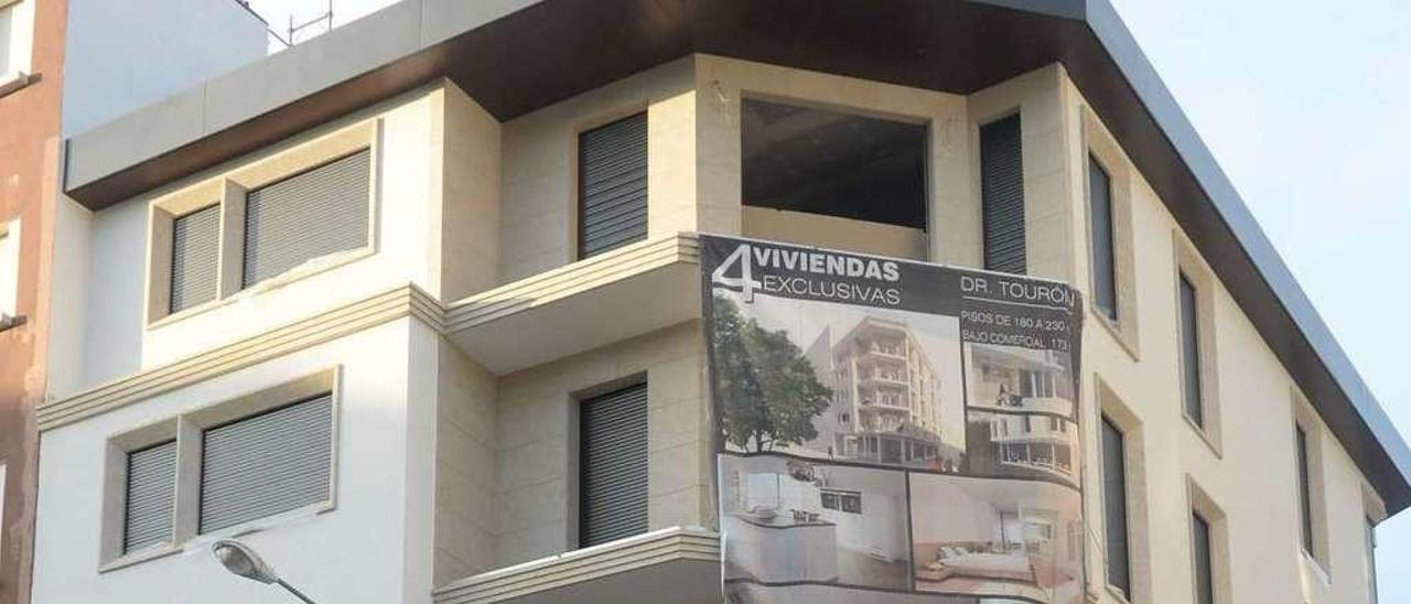 Un gran cartel anuncia la venta de varios pisos en un edificio del centro de Vilagarcía. // Noé Parga