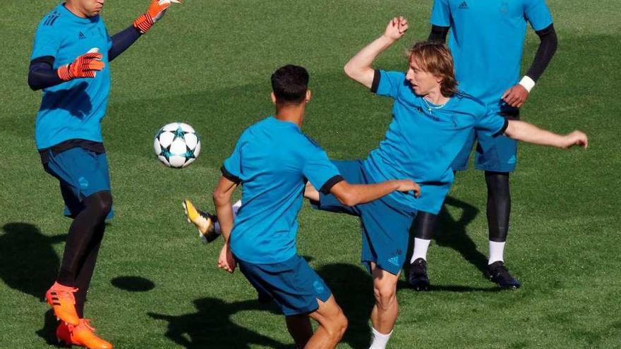 Modric, exjugador del club británico, toca el balón en un rondo junto a Keylor Navas, duda esta noche.