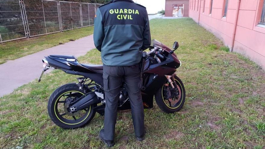La Guardia Civil con la moto del detenido.