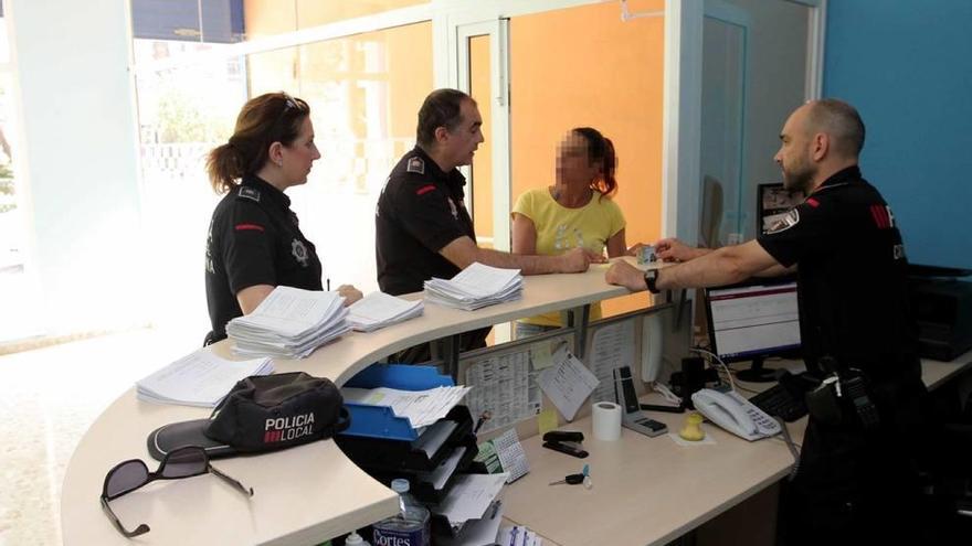 Varios agentes atendiendo a una vecina, ayer en la oficina del 092 en la plaza de El Lago.