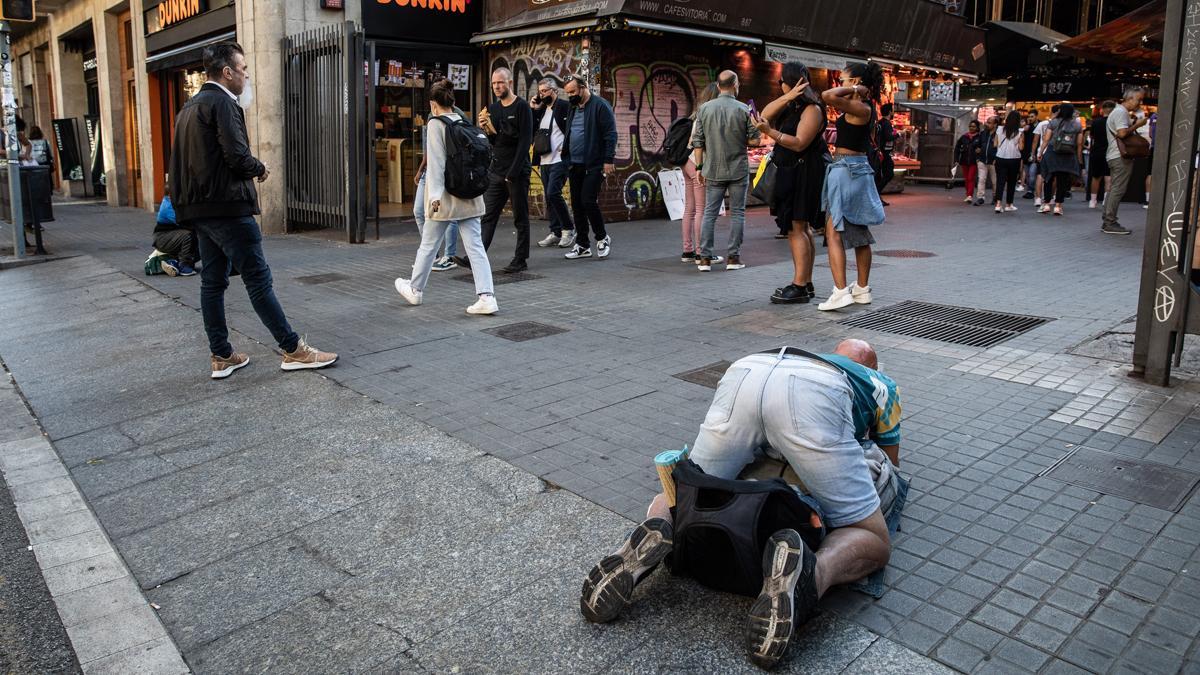 Un hombre pide caridad en, quién sabe, aquello que la ordenanza llama mendicidad insistente.