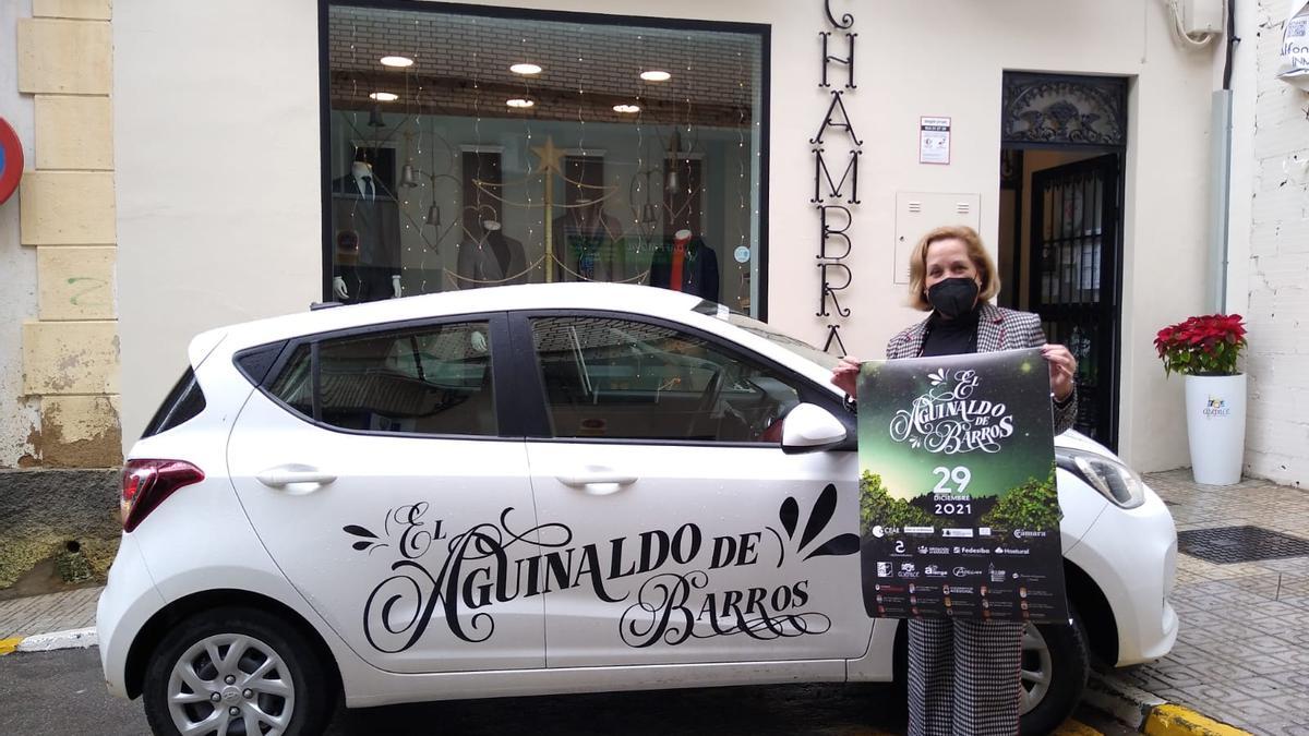 Una empresaria local posa con el coche de la cesta del Aguinaldo de Barros