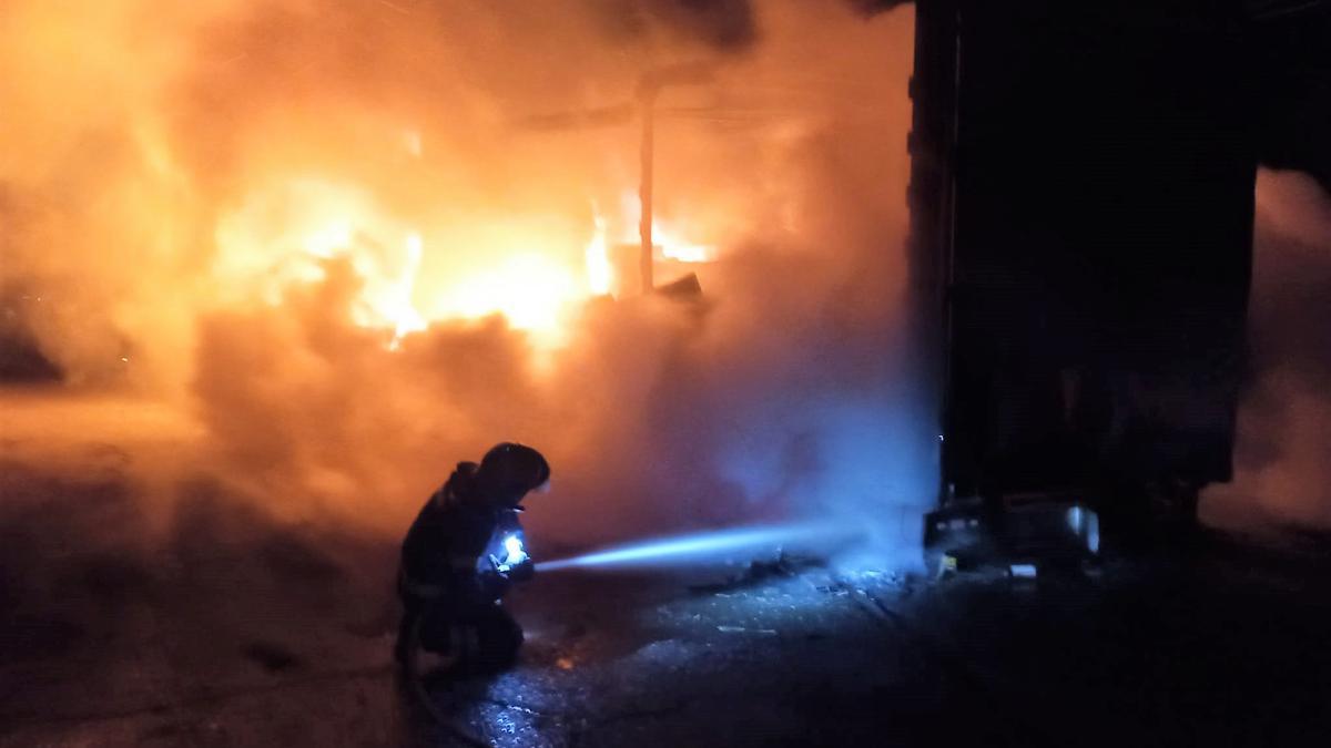 Un bombero durante las labores de extinción del incendio que calcinó un camión de lavadoras en la N-122.