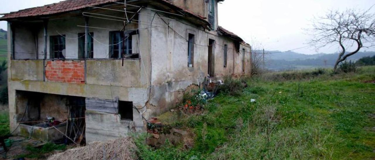 Arriba, la vivienda del fallecido. A la izquierda, el interior de la casa, con restos de basura almacenada.