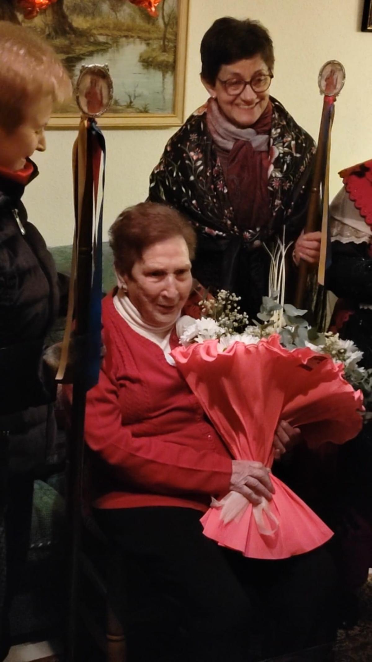 Las águedas entregan un ramos de flores a Juana Ruiz