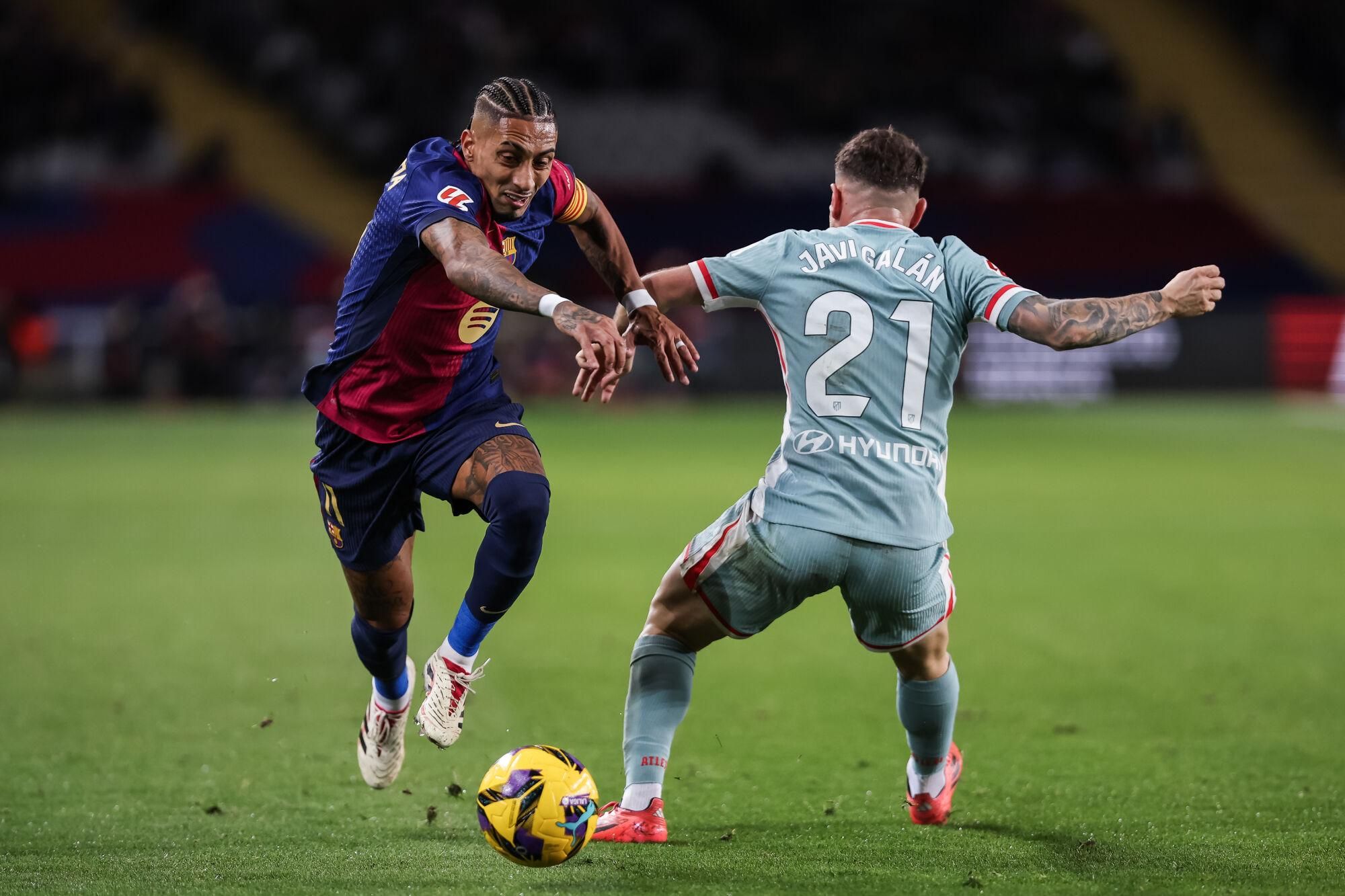 Raphinha Dias Belloli of FC Barcelona and Javi Galan of Atletico de Madrid in action during the Spanish league, La Liga EA Sports, football match played between FC Barcelona and Atletico de Madrid at Estadio Olimpico de Montjuic on December 21, 2024 in Barcelona, Spain. AFP7 21/12/2024 ONLY FOR USE IN SPAIN. Javier Borrego / AFP7 / Europa Press;2024;SOCCER;SPORT;ZSOCCER;ZSPORT;FC Barcelona v Atletico de Madrid - La Liga EA Sports;