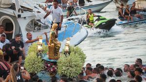 Unas personas sostiene la imagen de la Virgen del Mar, en la Isla Cristina.