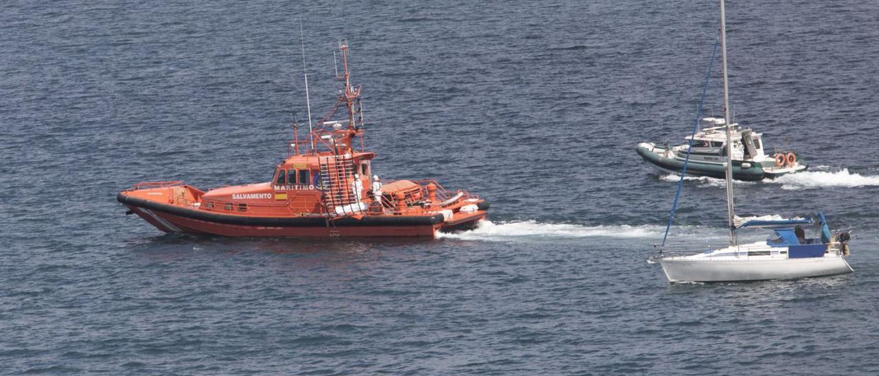 La embarcación de Salvamento Marítimo, en el momento de la recuperación del cadáver, junto a uno de los veleros que pasó junto al cuerpo y una lancha de la Guardia Civil.