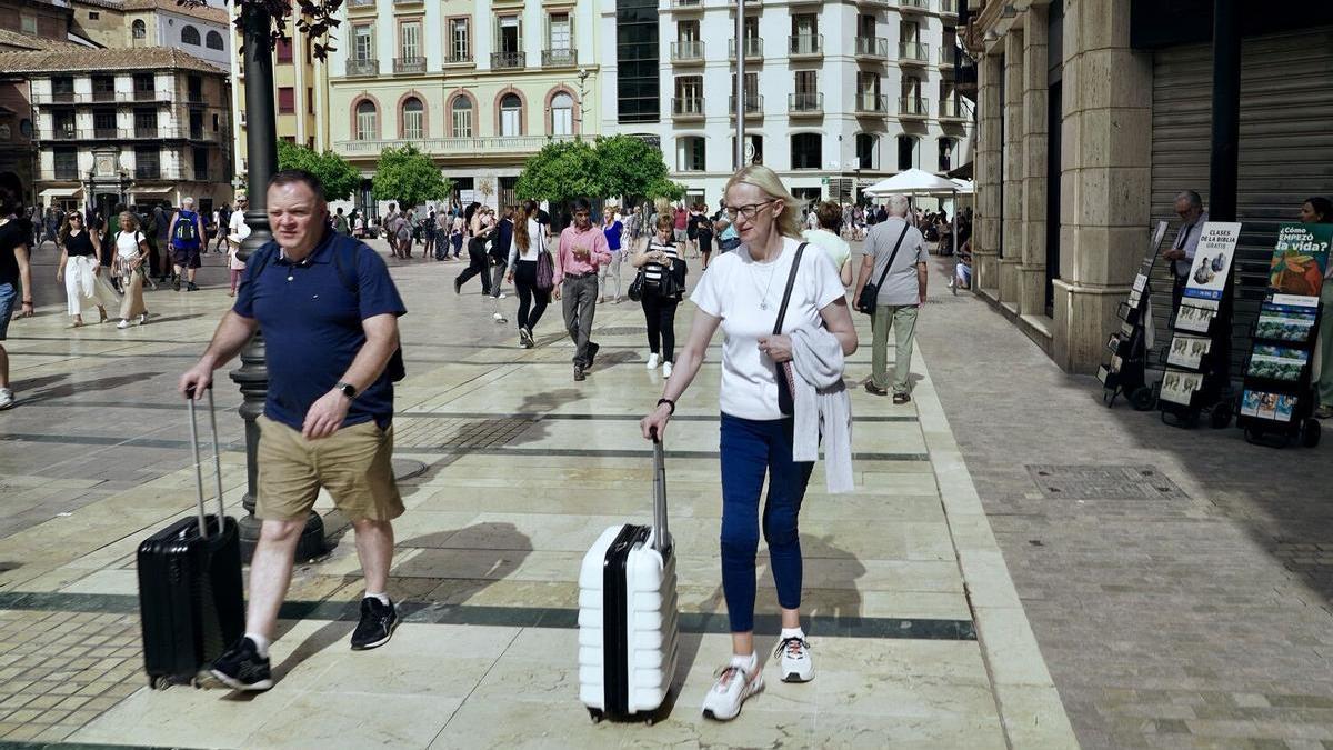 Turistas con sus maletas en el Centro de Málaga.