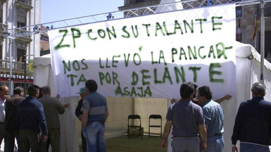 Miembros de la organización Asaja junto a la pancarta que fue sustraída el pasado jueves.