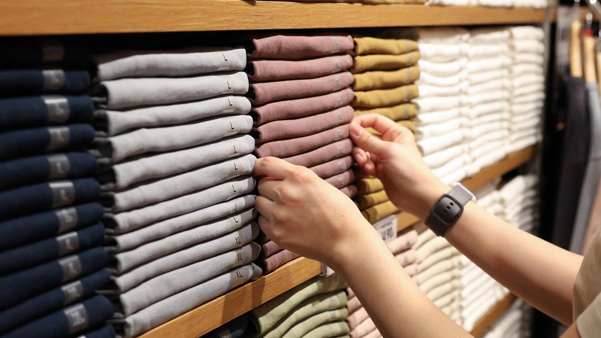 Archivo - Una dependienta coloca la ropa