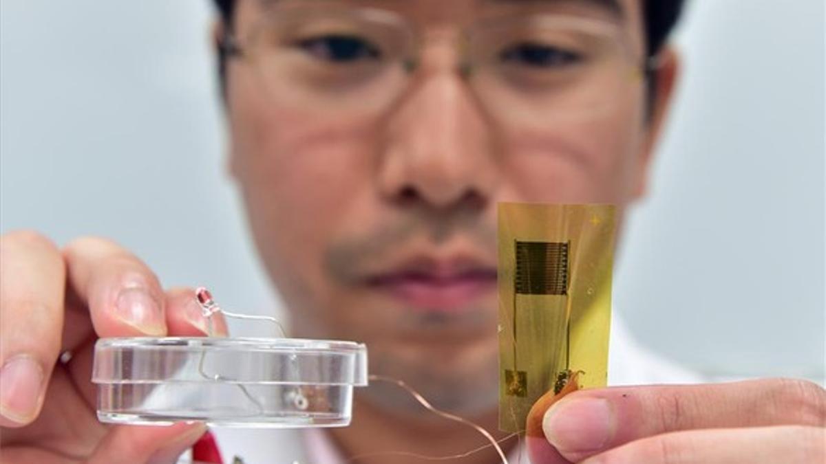 Un investigador de la Universidad de Tokio muestra el termómetro en forma de tirita.