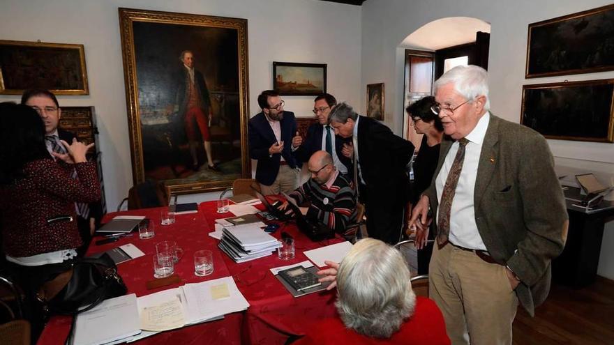 Al fondo, a la derecha, Rodrigo Cepeda, Juan Antonio Vázquez y José Luis García Delgado elaboran el acta del jurado. A la izquierda, el investigador y ganador del premio el año pasado Amador Menéndez charla con Marisa Morán, ayer, en el Museo Casa Natal de Jovellanos.