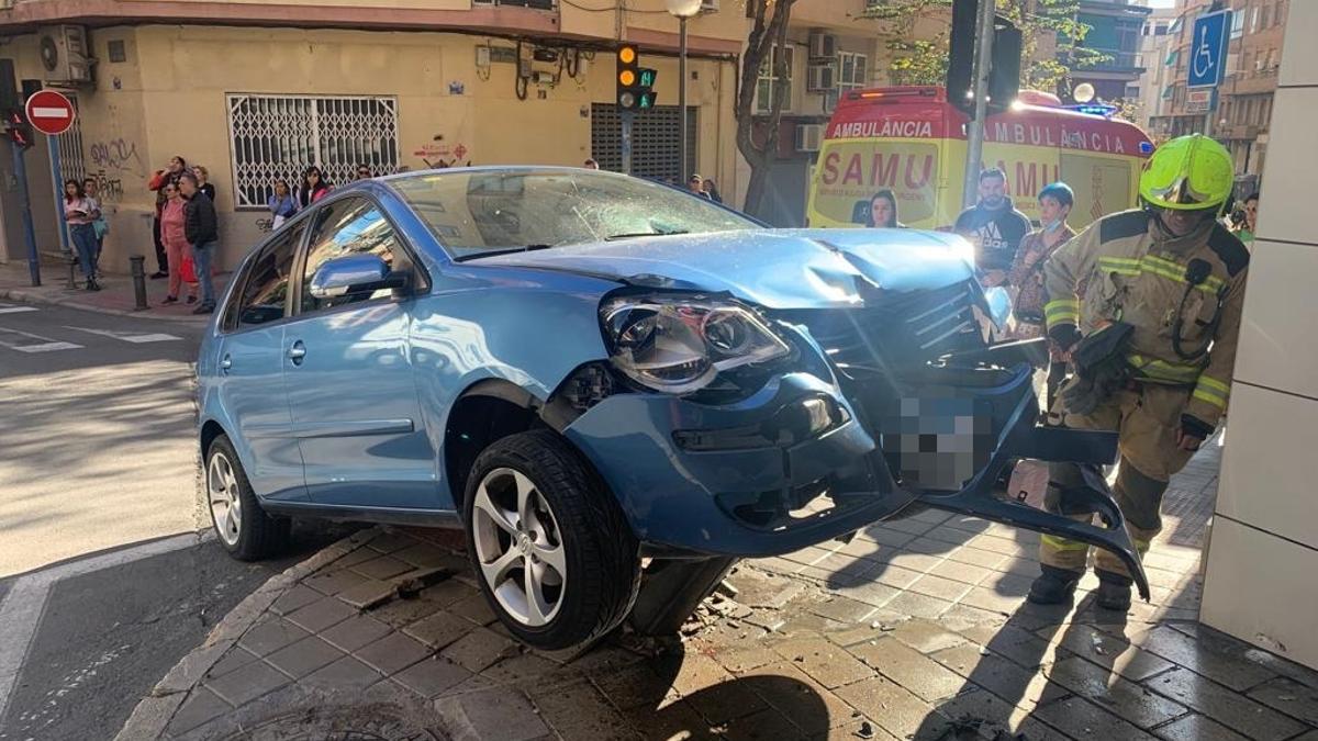 Bomberos examinan el coche accidentado en Alicante.