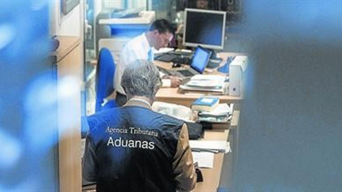 Investigación 8 Funcionarios de Aduanas, de la Agencia Tributaria, revisan documentación y ordenadores ayer en el despacho de Rato.